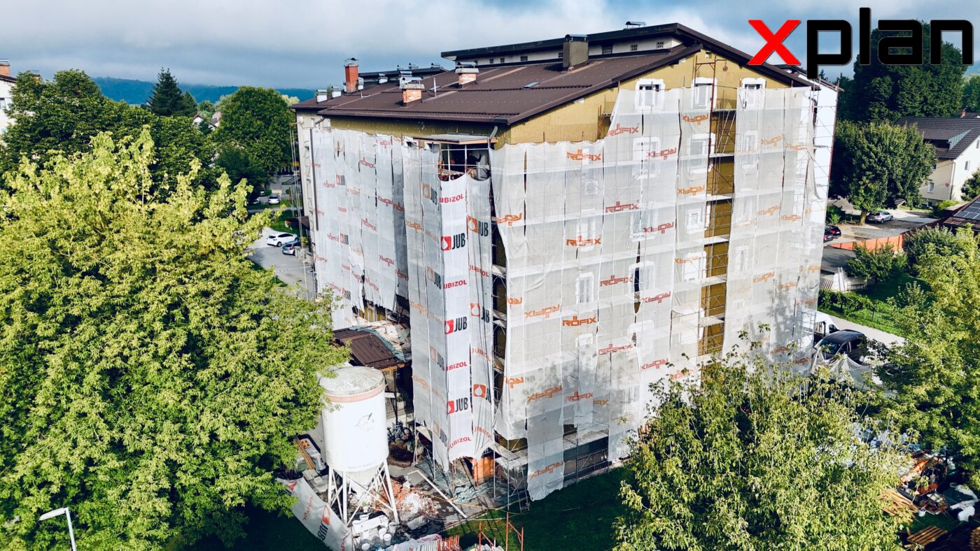 Večstanovanjska stavba med obnovo fasade z odrom in zaščitnimi mrežami